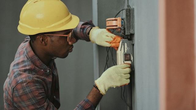 HVAC technician installing and calibrating split air conditioning cooling unit